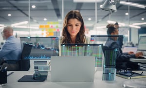 woman at computer with technology dashboards popping out of the screen